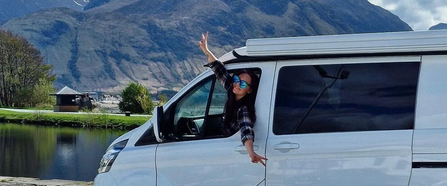 A woman leaning out a van window